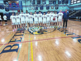 A group photo of the Basketball team, dressed in all white.